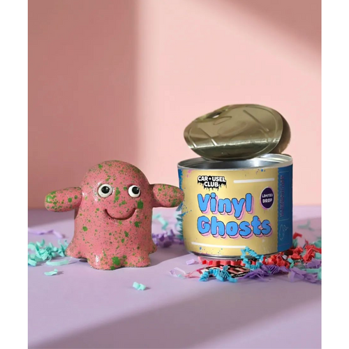 Pink glitter Vinyl Ghost next to an open Carousel Club Vinyl Ghosts tin