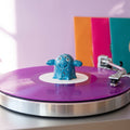 Series 002 Vinyl Ghost spindle topper spinning on a purple vinyl record