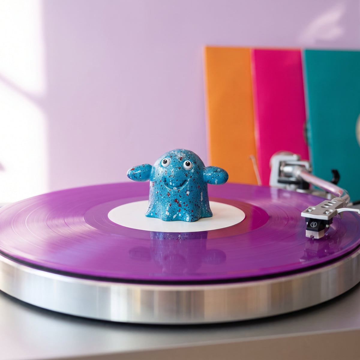 Series 002 Vinyl Ghost spindle topper spinning on a purple vinyl record
